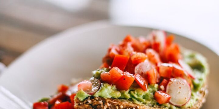 Delicious sandwiches with avocado and juicy tomato slices on rye bread pieces with sesame seeds