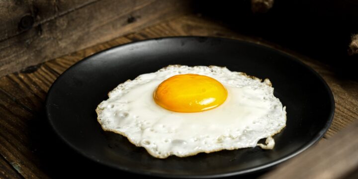 Close-Up Photo of a Sunny Side Up Egg on a Black Plate