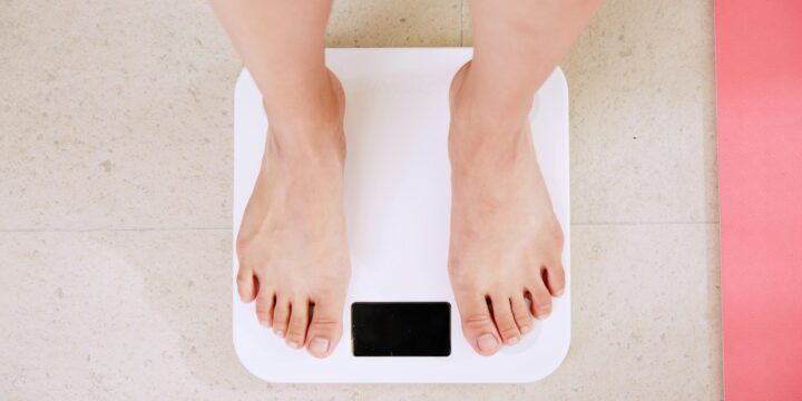 person standing on white digital bathroom scale