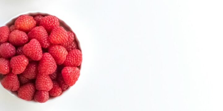 red and black berries on white surface