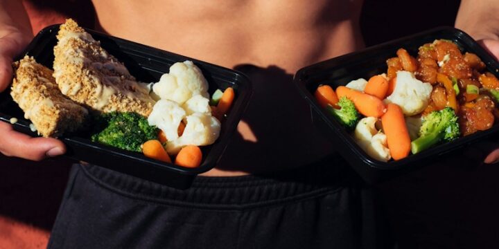 topless man in black shorts holding cooked food