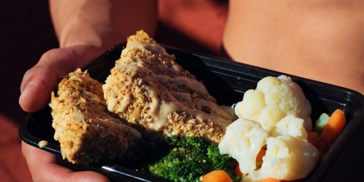 person holding cooked food on black tray