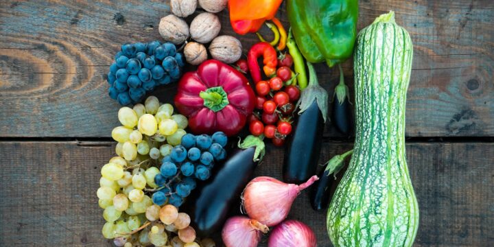 a variety of fruits and vegetables on a wooden surface