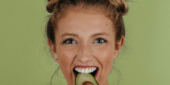 woman holding sliced avocado