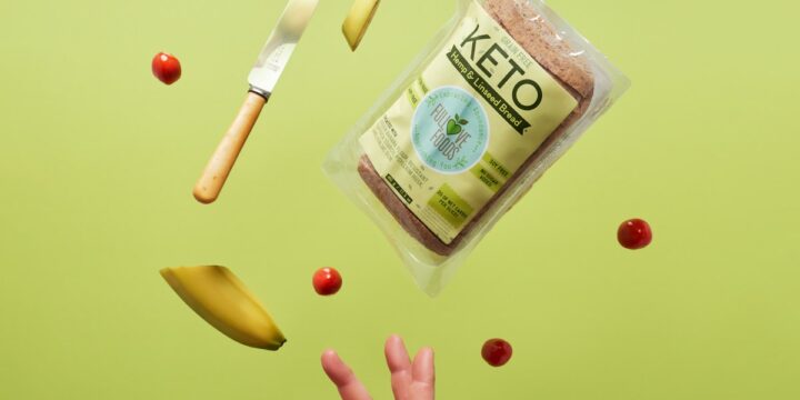 a hand reaching for a bag of food on a green background