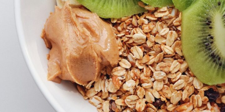 a bowl filled with oats, kiwi, and peanut butter